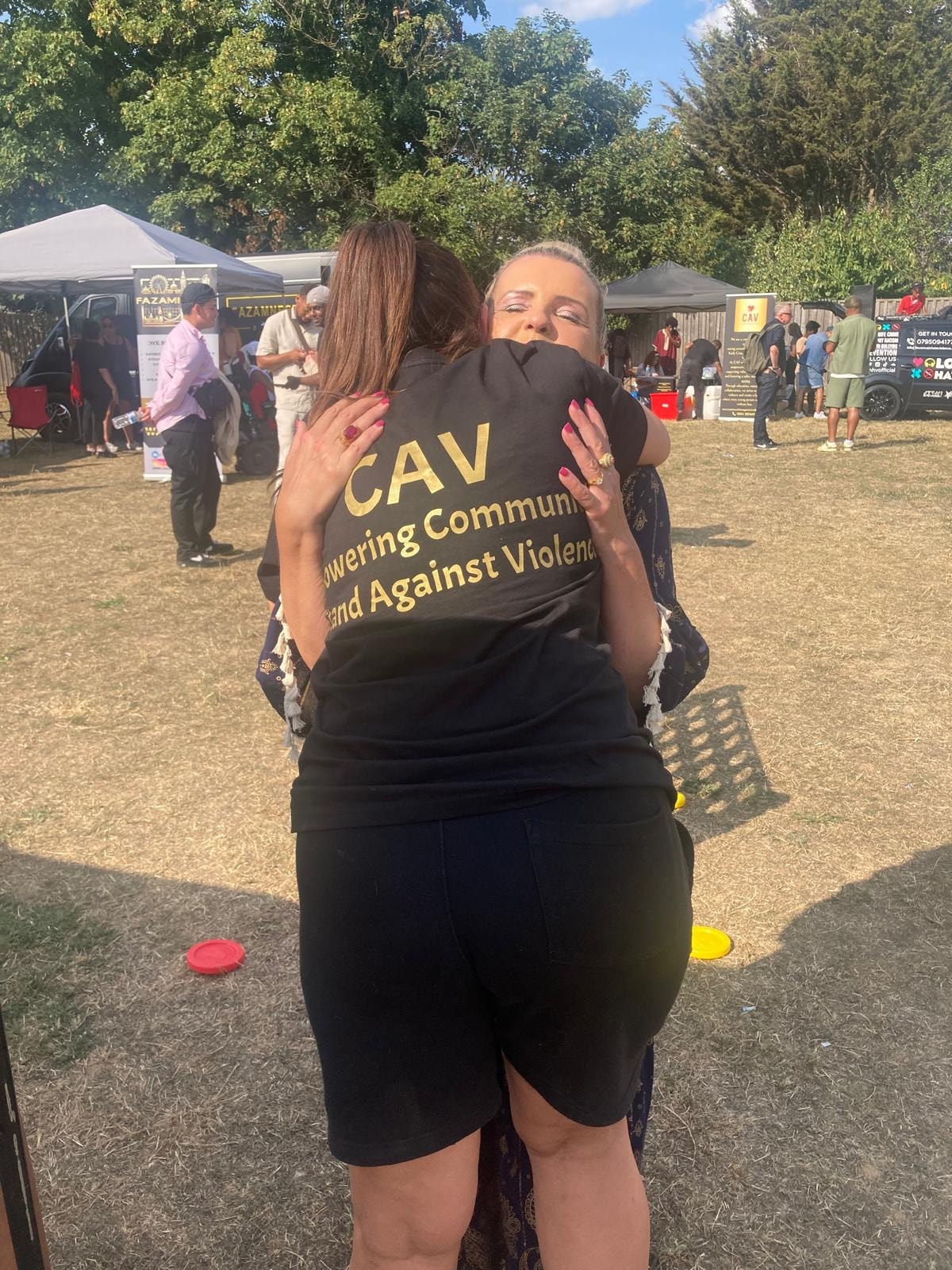 People hugging at a community violence awareness event